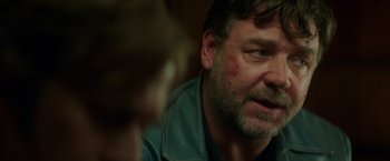 Movie still from “The Nice Guys” (2016), directed by Shane Black – A person sitting in a room; Close Up shot, Over the shoulder angle