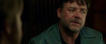 Movie still from “The Nice Guys” (2016), directed by Shane Black – A person wearing a green jacket; Close Up shot, Over the shoulder angle
