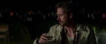 Movie still from “The Nice Guys” (2016), directed by Shane Black – A person holding a glass of wine; Close Up shot, Over the shoulder angle