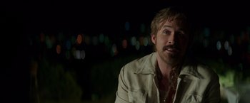 Movie still from “The Nice Guys” (2016), directed by Shane Black – A person wearing a suit and tie; Close Up shot, Over the shoulder angle