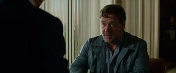 Movie still from “The Nice Guys” (2016), directed by Shane Black – A person sitting in a room; Close Up shot, Over the shoulder angle