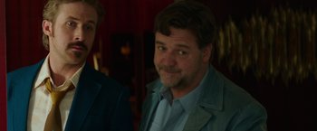 Movie still from “The Nice Guys” (2016), directed by Shane Black – A person wearing a jacket and a tie; Close Up shot, Over the shoulder angle