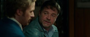 Movie still from “The Nice Guys” (2016), directed by Shane Black – A man in a blue jacket is talking to another man; Close Up shot, Over the shoulder angle