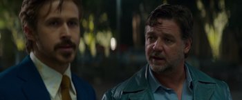 Movie still from “The Nice Guys” (2016), directed by Shane Black – A man in a leather jacket and a man in a blue shirt; Close Up shot, Over the shoulder angle