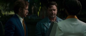 Movie still from “The Nice Guys” (2016), directed by Shane Black – Two men are looking at something in a mirror; Medium shot, Over the shoulder angle