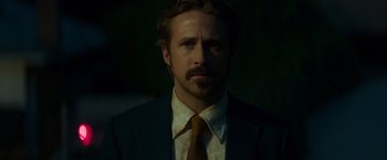 Movie still from “The Nice Guys” (2016), directed by Shane Black – A person wearing a suit and tie; Close Up shot, Low angle