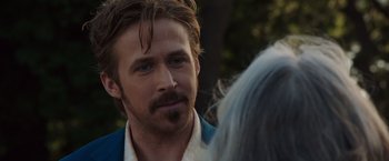 Movie still from “The Nice Guys” (2016), directed by Shane Black – A person with a beard and mustache; Close Up shot, Over the shoulder angle