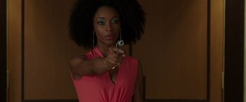 Movie still from “The Nice Guys” (2016), directed by Shane Black – A woman in a pink shirt holding a gun; Close Up shot, Over the shoulder angle