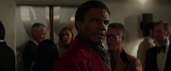 Movie still from “The Nice Guys” (2016), directed by Shane Black – A person wearing a suit and tie; Close Up shot, Over the shoulder angle