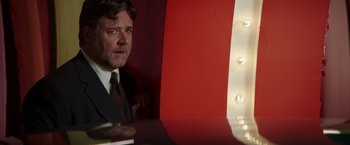Movie still from “The Nice Guys” (2016), directed by Shane Black – A person wearing a suit and tie; Medium shot, Over the shoulder angle