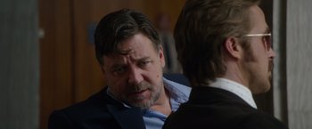 Movie still from “The Nice Guys” (2016), directed by Shane Black – A man in a suit talking to another man in a suit; Close Up shot, Over the shoulder angle