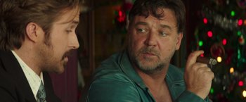 Movie still from “The Nice Guys” (2016), directed by Shane Black – A man in a green shirt talking to another man in a blue shirt; Close Up shot, Over the shoulder angle