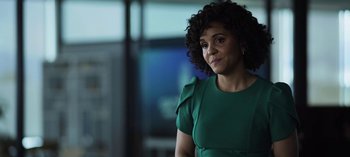 Movie still from “The Night Agent” (2023), created by Shawn Ryan – A woman in a green dress is standing in a room; Close Up shot, Over the shoulder angle