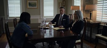 Movie still from “The Night Agent” (2023), created by Shawn Ryan – Three people sitting at a table in a room; Medium shot, Over the shoulder angle