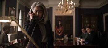 Movie still from “The Night Agent” (2023), created by Shawn Ryan – A woman on the phone in front of another woman; Medium shot, Low angle