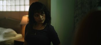 Movie still from “The Night Agent” (2023), created by Shawn Ryan – A woman in a black shirt is standing in a room; Close Up shot, Low angle