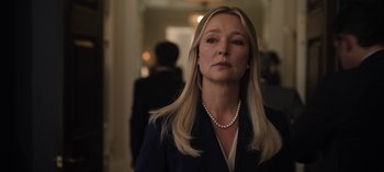 Movie still from “The Night Agent” (2023), created by Shawn Ryan – A woman in a black jacket and a pearl necklace; Close Up shot, Low angle