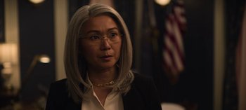 Movie still from “The Night Agent” (2023), created by Shawn Ryan – A woman in a white shirt and a black jacket; Close Up shot, Over the shoulder angle