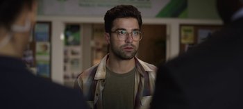Movie still from “The Night Agent” (2023), created by Shawn Ryan – A person wearing glasses and a plaid shirt; Close Up shot, Over the shoulder angle