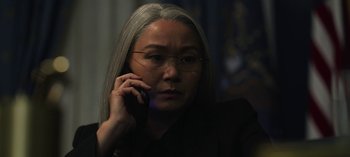 Movie still from “The Night Agent” (2023), created by Shawn Ryan – An older woman talking on a cell phone; Close Up shot, Over the shoulder angle