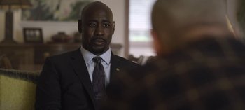 Movie still from “The Night Agent” (2023), created by Shawn Ryan – A man in a suit and tie in front of another man in a suit and tie; Close Up shot, Over the shoulder angle