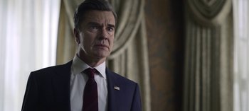 Movie still from “The Night Agent” (2023), created by Shawn Ryan – A man in a suit and a tie; Close Up shot, Low angle