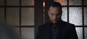 Movie still from “The Night Agent” (2023), created by Shawn Ryan – A person wearing a suit and tie; Close Up shot, Over the shoulder angle