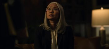 Movie still from “The Night Agent” (2023), created by Shawn Ryan – A woman with long white hair wearing a black jacket; Close Up shot, Low angle