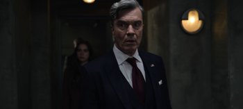 Movie still from “The Night Agent” (2023), created by Shawn Ryan – A man in a suit and a woman in a red tie; Medium shot, Over the shoulder angle