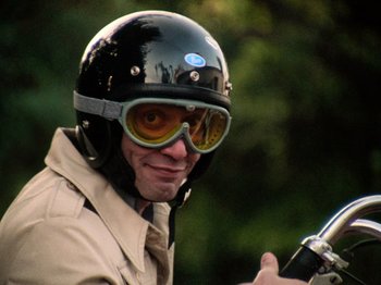 Movie still from “The Other Side of the Wind” (2018), directed by Orson Welles – A man wearing a motorcycle helmet and goggles; Close Up shot, Low angle
