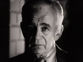 Movie still from “The Other Side of the Wind” (2018), directed by Orson Welles – An older man wearing a suit and a tie; Close Up shot, Low angle