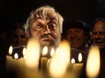 Movie still from “The Other Side of the Wind” (2018), directed by Orson Welles – An old man with a beard and a bunch of lit candles in front of him; Close Up shot, Low angle