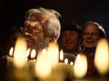 Movie still from “The Other Side of the Wind” (2018), directed by Orson Welles – An old man with a white beard is looking at a group of candles; Close Up shot, Low angle