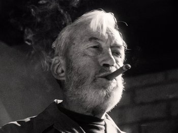 Movie still from “The Other Side of the Wind” (2018), directed by Orson Welles – An old man with a beard smoking a cigarette; Close Up shot, Low angle