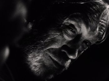 Movie still from “The Other Side of the Wind” (2018), directed by Orson Welles – A man's face in a black and white photo; Extreme Close Up shot, Low angle