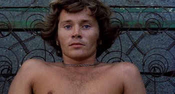 Movie still from “The Other Side of the Wind” (2018), directed by Orson Welles – A man with long hair and blue eyes is posing for the camera; Close Up shot, Overhead angle