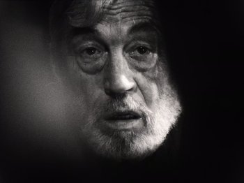Movie still from “The Other Side of the Wind” (2018), directed by Orson Welles – An old man with a beard is looking at the camera; Close Up shot, Over the shoulder angle