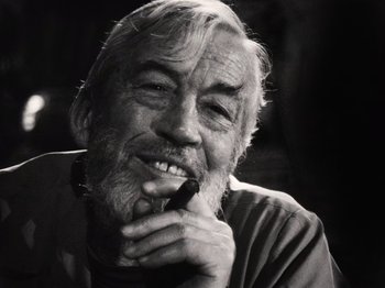 Movie still from “The Other Side of the Wind” (2018), directed by Orson Welles – An older man smoking a cigarette while looking at the camera; Close Up shot, Low angle