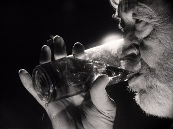 Movie still from “The Other Side of the Wind” (2018), directed by Orson Welles – A cat drinking water from a glass bottle; Extreme Close Up shot, Low angle