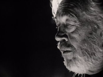 Movie still from “The Other Side of the Wind” (2018), directed by Orson Welles – An old man with a beard is looking into the distance; Close Up shot, Low angle