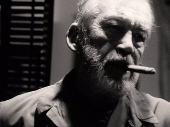 Movie still from “The Other Side of the Wind” (2018), directed by Orson Welles – An older man smoking a cigarette in a black and white photo; Close Up shot, Low angle