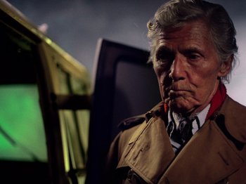 Movie still from “The Other Side of the Wind” (2018), directed by Orson Welles – An older man wearing a trench coat and a tie; Close Up shot, Low angle