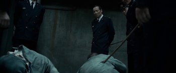 Movie still from “The Outsider” (2018), directed by Martin Zandvliet – A man standing in front of a group of people; Medium shot, Low angle