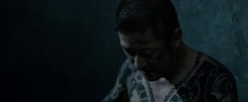 Movie still from “The Outsider” (2018), directed by Martin Zandvliet – A man with a chain around his neck; Close Up shot, High angle