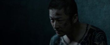 Movie still from “The Outsider” (2018), directed by Martin Zandvliet – A person with a tattoo on his face; Close Up shot, High angle