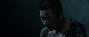 Movie still from “The Outsider” (2018), directed by Martin Zandvliet – A man with a tattoo on his arm and face; Close Up shot, High angle