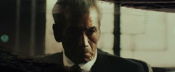 Movie still from “The Outsider” (2018), directed by Martin Zandvliet – An older man in a suit and tie; Extreme Close Up shot, Low angle