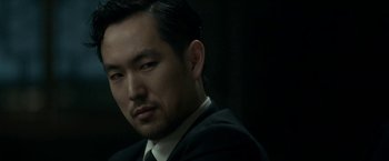 Movie still from “The Outsider” (2018), directed by Martin Zandvliet – A person wearing a suit and tie; Close Up shot, Over the shoulder angle