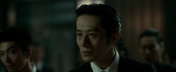 Movie still from “The Outsider” (2018), directed by Martin Zandvliet – A person wearing a suit and tie; Close Up shot, Low angle