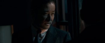 Movie still from “The Outsider” (2018), directed by Martin Zandvliet – A person wearing a suit and tie; Close Up shot, Over the shoulder angle